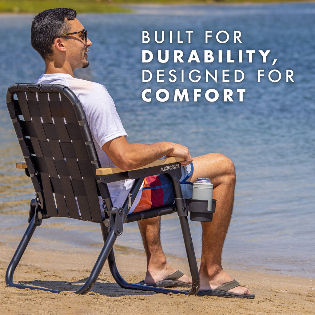 a man sitting in a chair on the beach with words built for durability, designed for comfort