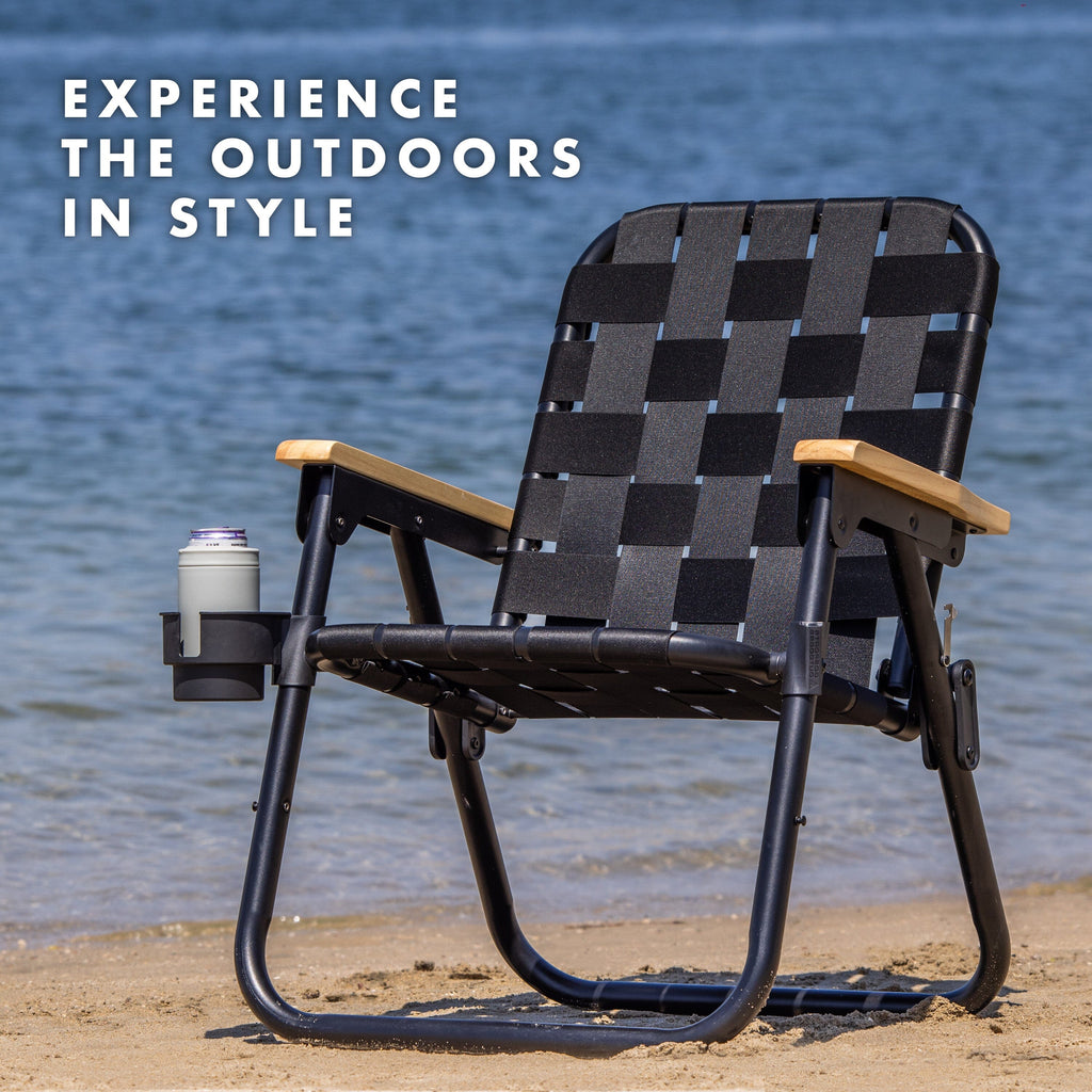 a black chair on the beach with the words experience the outdoors in style