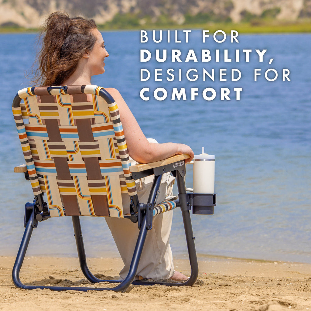 a woman sitting in a chair on the beach