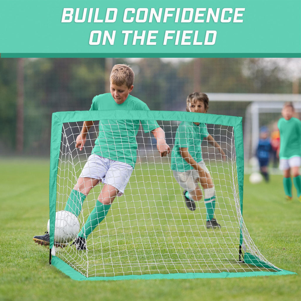 a young boy kicking a soccer ball in a goal net