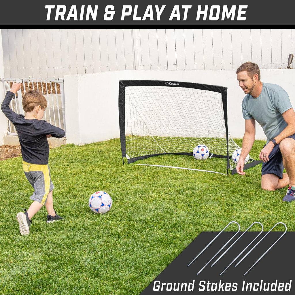 a man and a young boy playing soccer in the backyard