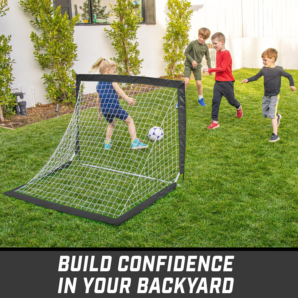 a backyard soccer goal with two kids playing in it