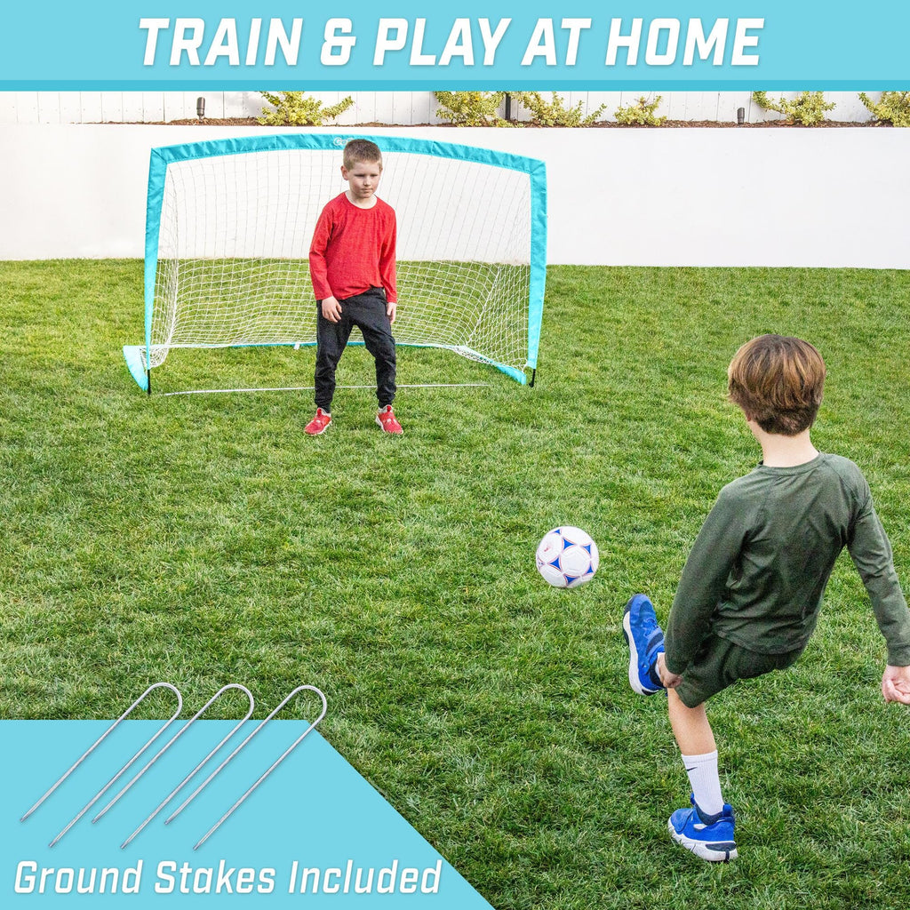 a boy playing soccer with a soccer goal