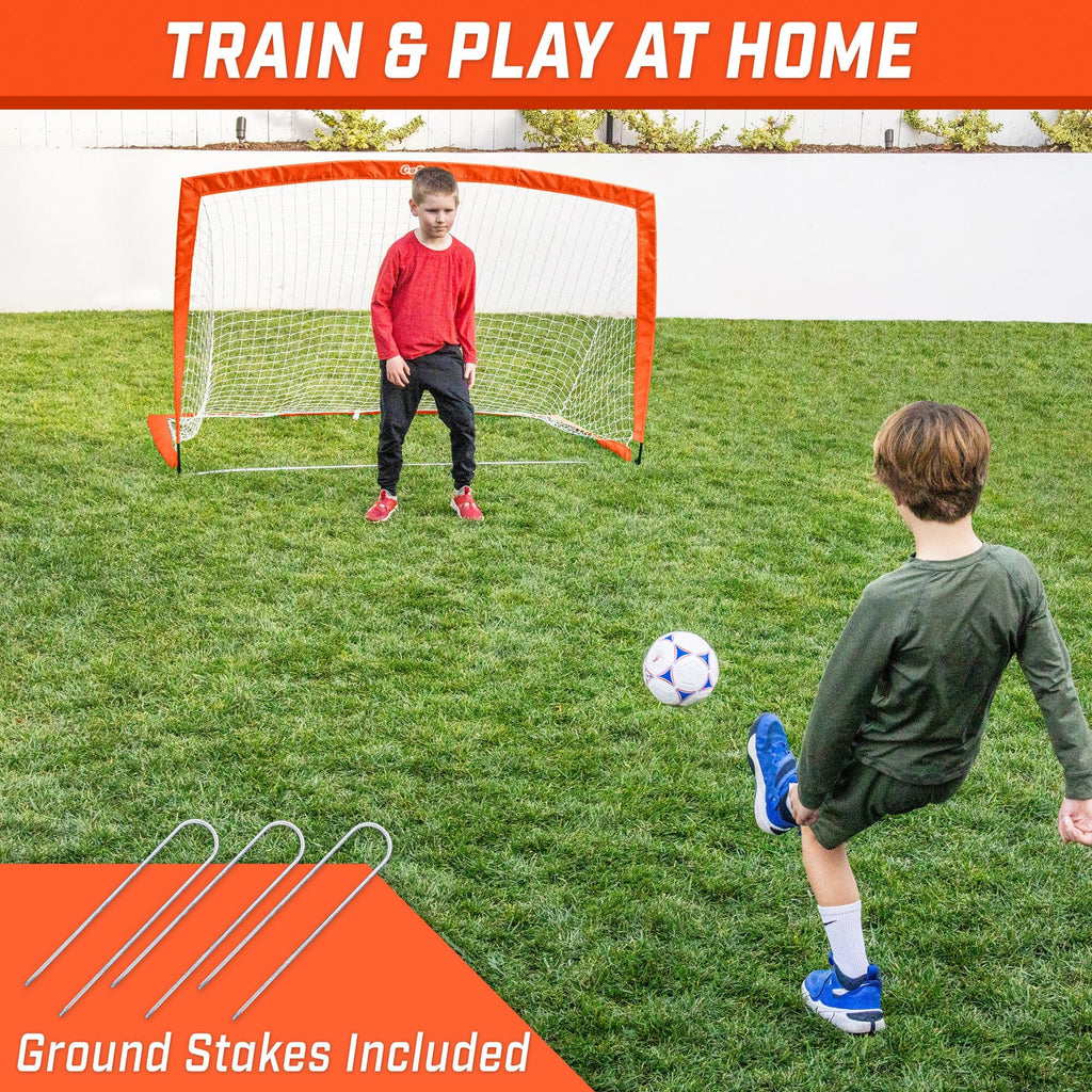 a young boy playing soccer with a soccer goal