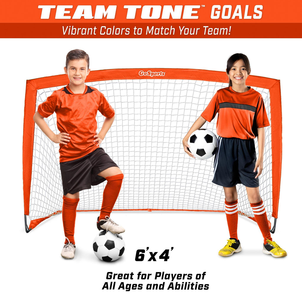 a young boy and girl are posing for a soccer goal