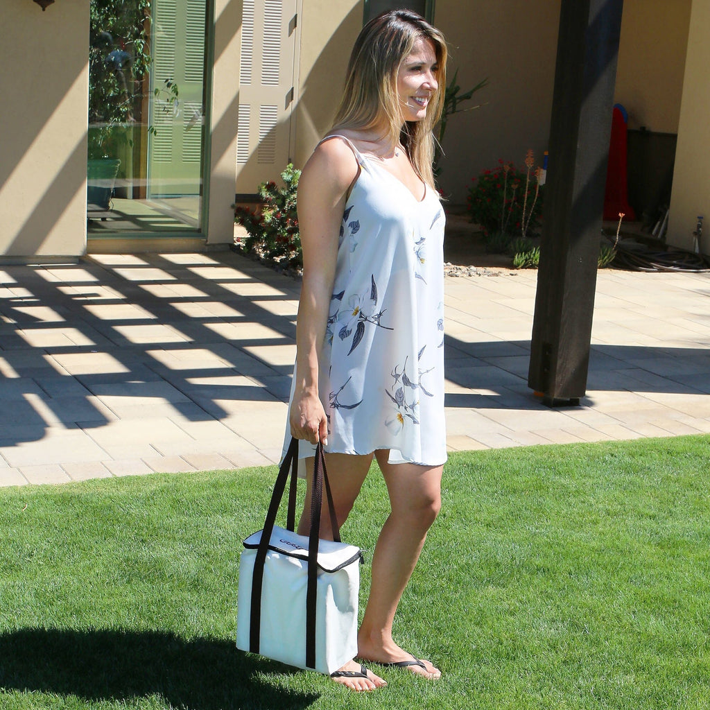 a woman in a white dress is holding a white bag