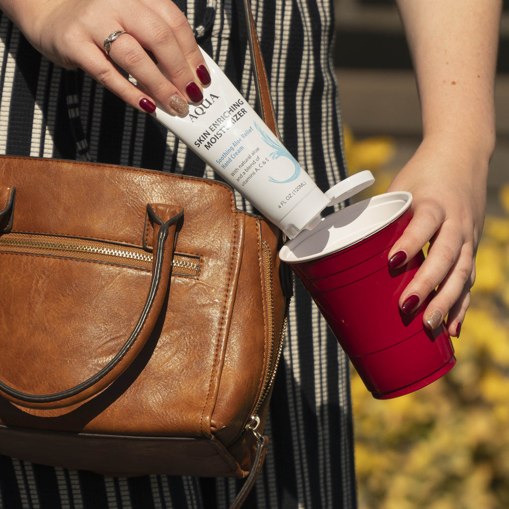 a woman holding a brown bag and a red cup